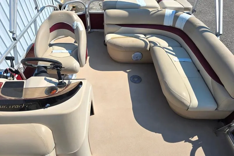 Slide: The Image of 2012 Sun Tracker 22 Party Barge Deluxe interior with beige seating and steering console. - 5