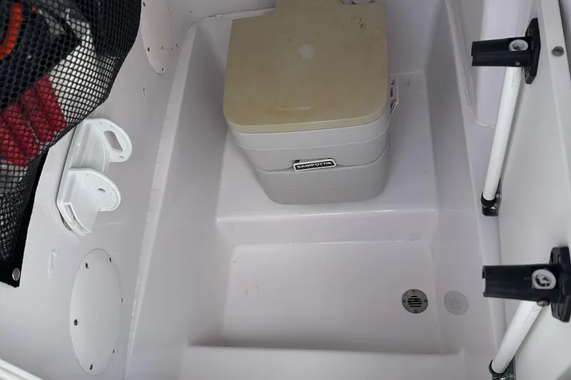 Slide: The Image of 2003 PROLINE Sport Center Console boat interior with portable toilet and storage. - 13