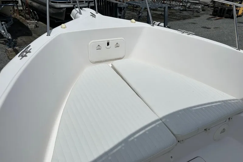 Slide: The Image of 2003 PROLINE Sport Center Console boat with white seating and storage compartment. - 14