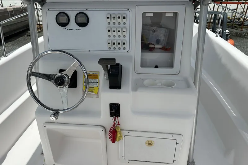 Slide: The Image of 2003 PROLINE Sport Center Console boat dashboard with steering wheel and controls. - 2