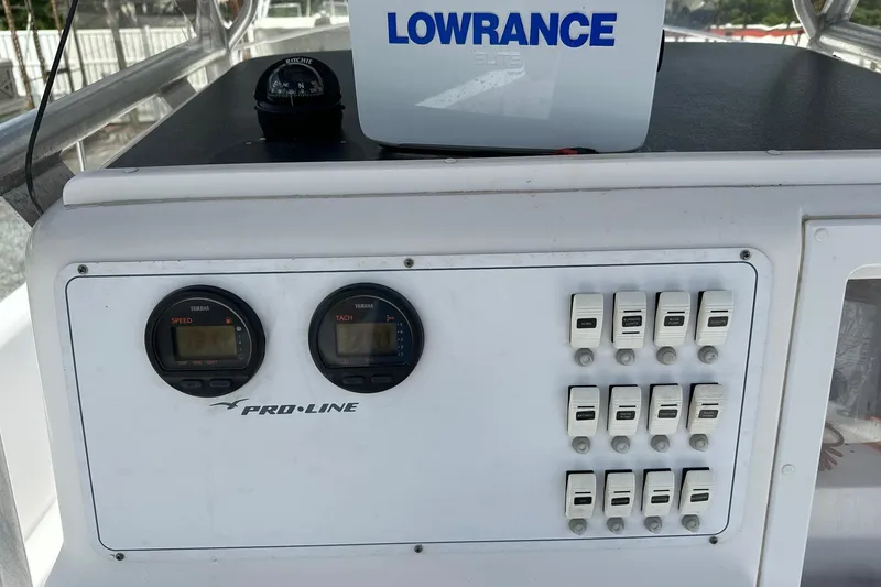 Slide: The Image of 2003 PROLINE Sport Center Console dashboard with gauges and switches, featuring Lowrance equipment. - 4