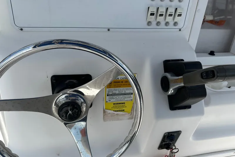 Slide: The Image of 2003 PROLINE Sport Center Console steering wheel and controls, featuring switches and warning label. - 5