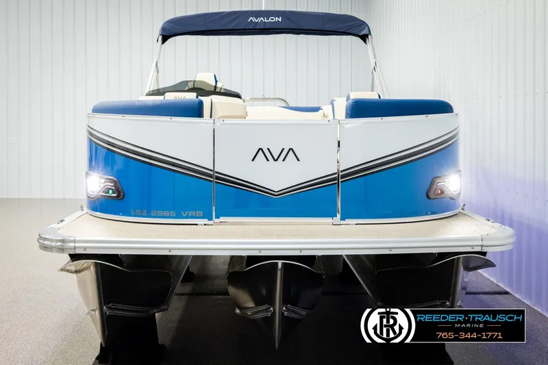 Slide: The Image of 2026 Avalon LSZ VRB pontoon boat in showroom, blue and white design, front view. - 8