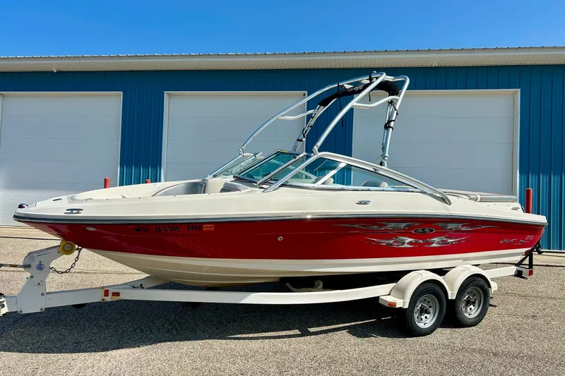 Slide: The Image of 2008 Searay 205 SPORT boat with red and white design on a trailer. - 17