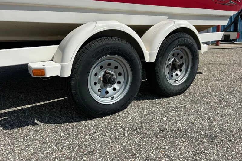 Slide: The Image of Trailer wheels of a 2008 Searay 205 SPORT boat on asphalt surface. - 18