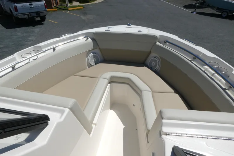 Slide: The Image of 2025 Boston Whaler 210 Vantage boat interior with cushioned seating and cup holders. - 11