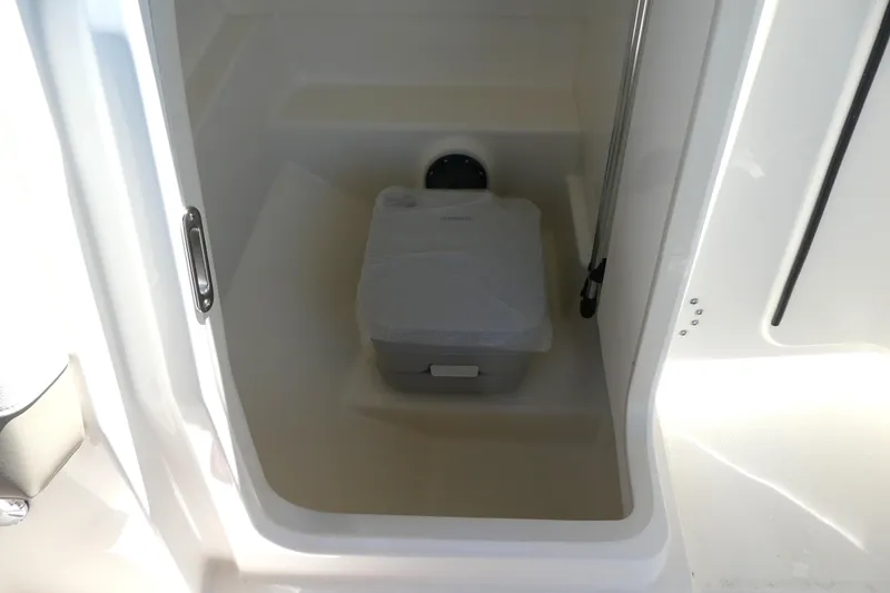 Slide: The Image of Interior of 2025 Boston Whaler 210 Vantage boat, featuring a compact storage area. - 13