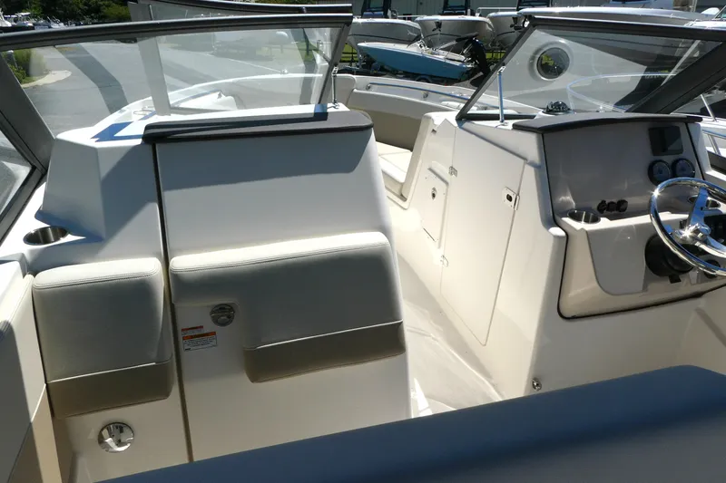 Slide: The Image of 2025 Boston Whaler 210 Vantage boat interior with steering wheel and seating area. - 8
