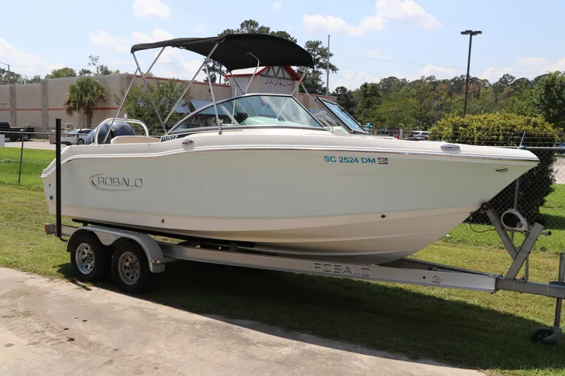 Slide: The Image of 2019 Robalo R207 Dual Console boat on trailer, parked outdoors. - 0