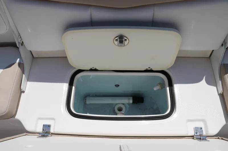 Slide: The Image of 2019 Robalo R207 Dual Console livewell with open lid, showcasing interior features. - 10
