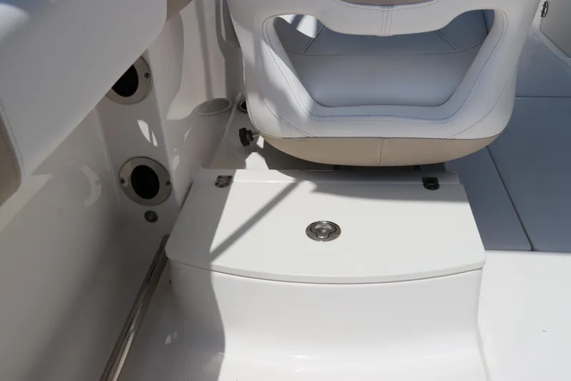 Slide: The Image of 2019 Robalo R207 Dual Console boat interior with white seating and storage compartment. - 15