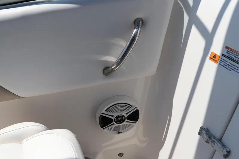 Slide: The Image of 2019 Robalo R207 Dual Console interior with speaker and stainless steel handle. - 22