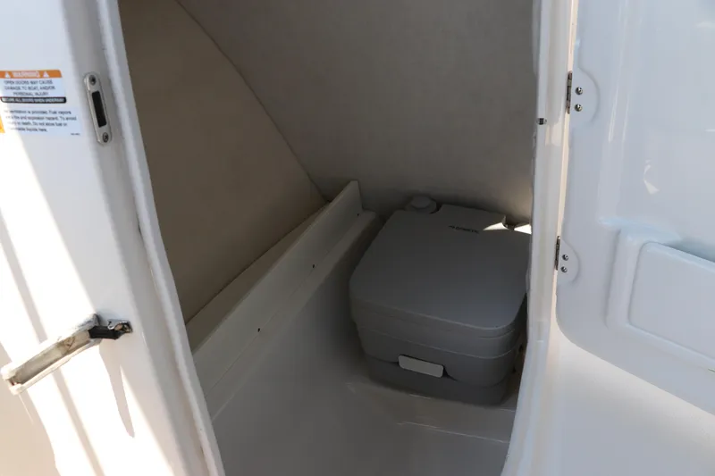 Slide: The Image of 2019 Robalo R207 Dual Console boat interior with portable toilet. - 24