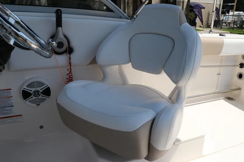 Slide: The Image of 2019 Robalo R207 Dual Console boat interior with white captain's seat and steering wheel. - 26