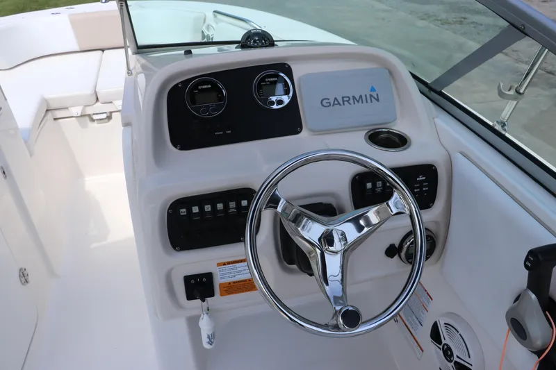 Slide: The Image of 2019 Robalo R207 Dual Console boat dashboard with Garmin navigation and steering wheel. - 27