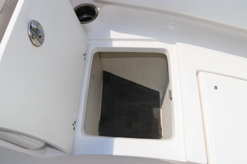 Slide: The Image of 2019 Robalo R207 Dual Console storage compartment with open hatch and non-slip mat. - 44