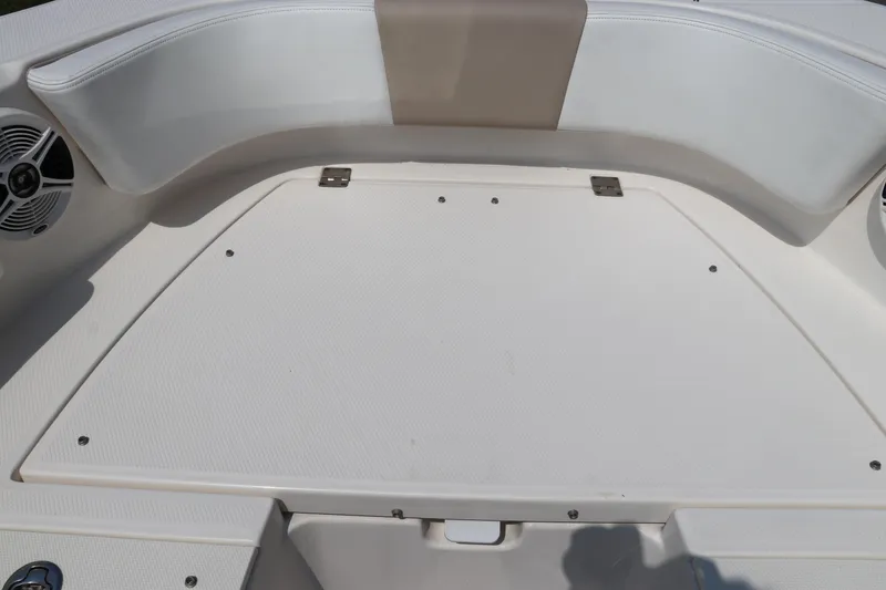 Slide: The Image of 2019 Robalo R207 Dual Console boat interior with white seating and storage compartment. - 45