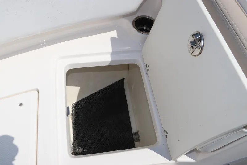 Slide: The Image of 2019 Robalo R207 Dual Console storage compartment with open hatch and latch. - 48