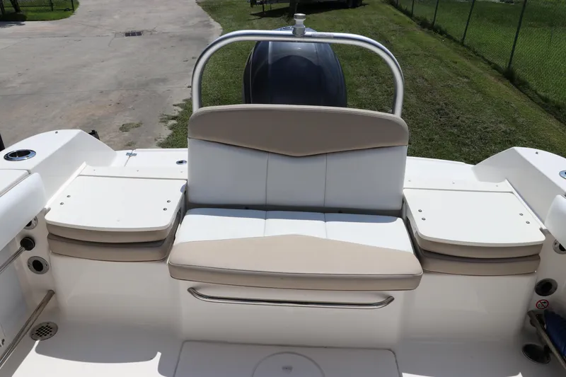 Slide: The Image of 2019 Robalo R207 Dual Console boat seating area with cushioned bench and storage compartments. - 5