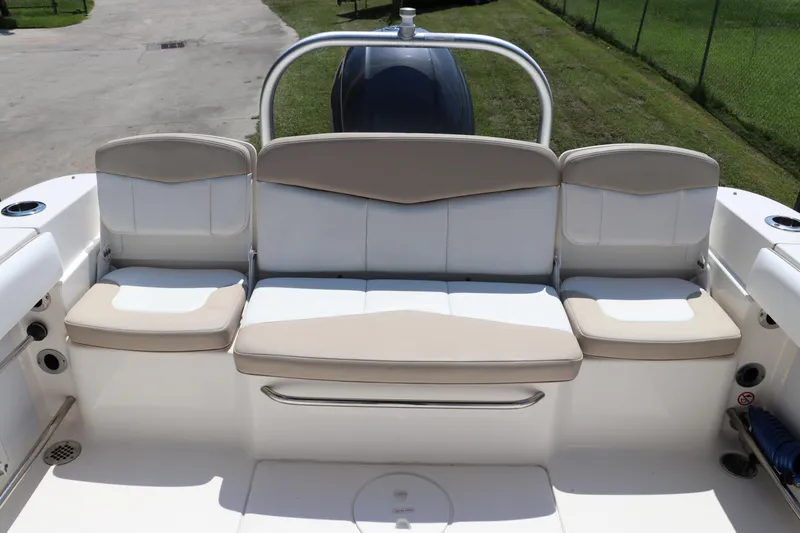Slide: The Image of 2019 Robalo R207 Dual Console boat seating area with beige and white cushions. - 6