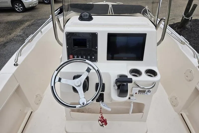 Slide: The Image of 2024 Grady-White Fisherman 180 boat console with steering wheel and navigation screens. - 13