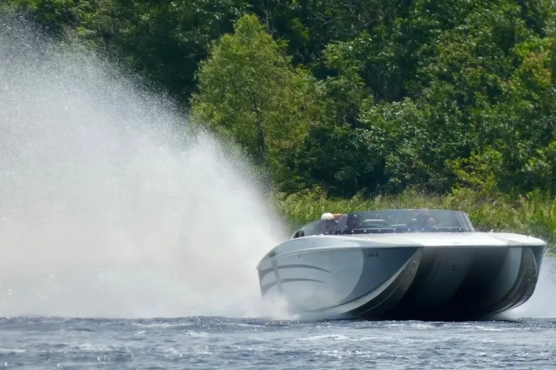 Slide: The Image of High-speed RPM REDLINE 2008 powerboat racing on a lake with lush green forest backdrop. - 4
