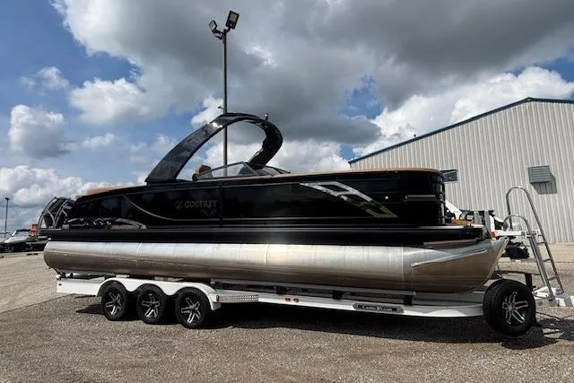 Slide: The Image of 2025 Godfrey San Pan SP2700SBW pontoon boat on trailer, parked outdoors under cloudy sky. - 34
