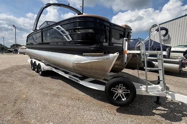Slide: The Image of 2025 Godfrey San Pan SP2700SBW pontoon boat on a trailer, parked outdoors. - 36