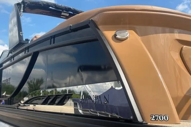 Slide: The Image of 2025 Godfrey San Pan SP2700SBW boat, sleek design, glossy finish, under blue sky. - 41