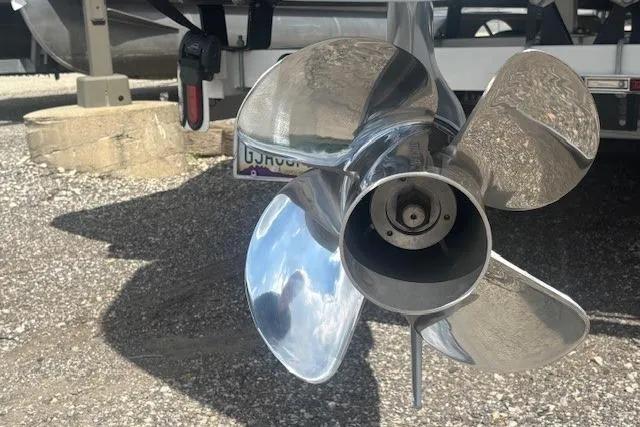 Slide: The Image of Shiny boat propeller of a 2025 Godfrey San Pan SP2700SBW on gravel surface. - 45