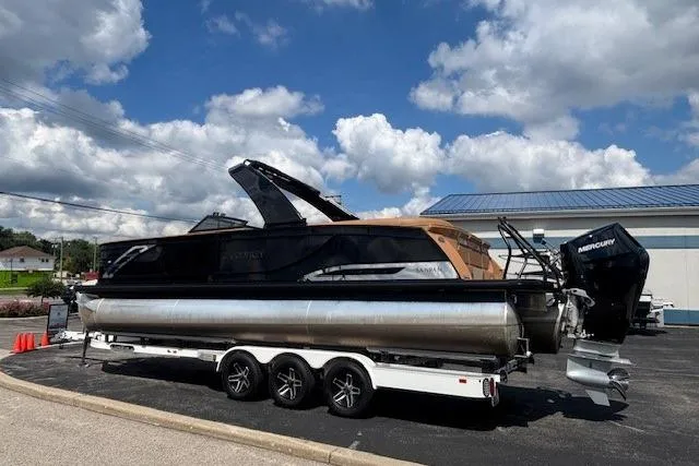 Slide: The Image of 2025 Godfrey SAN PAN SP 2700 SBW pontoon boat on trailer, under a cloudy sky. - 51
