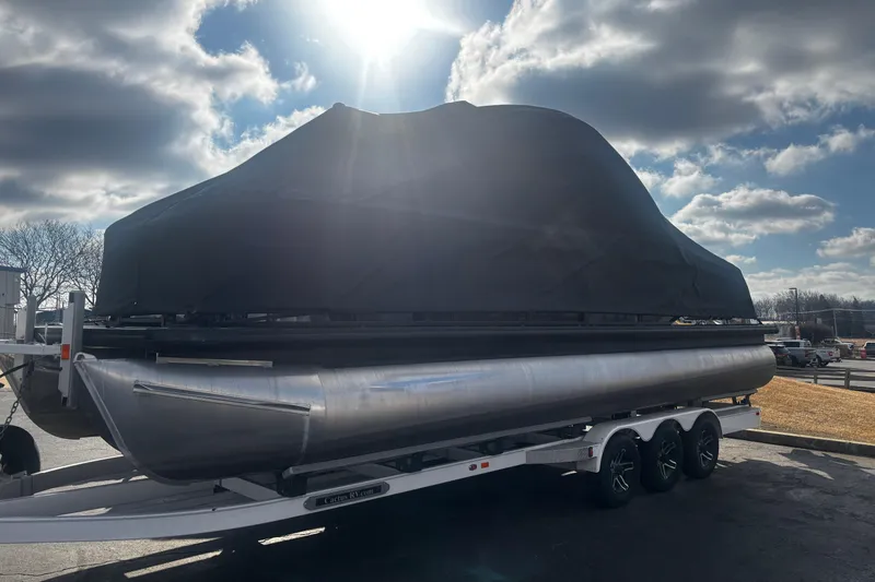 Slide: The Image of 2025 Godfrey SAN PAN SP 2700 SBW pontoon boat covered on trailer under cloudy sky. - 57