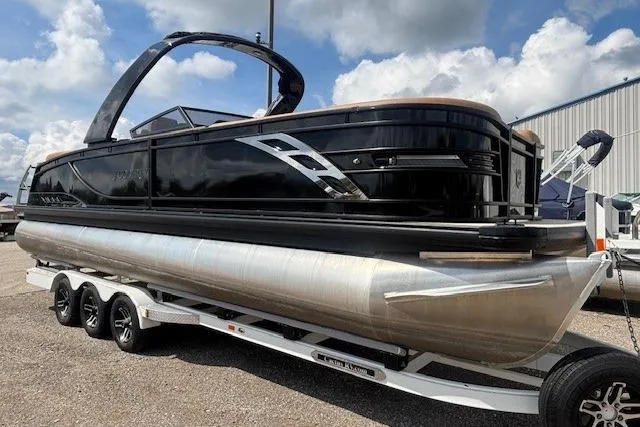 Slide: The Image of 2025 Godfrey San Pan SP2700SBW pontoon boat on trailer, under a cloudy sky. - 9