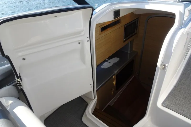 Slide: The Image of Interior cabin view of 2015 Chaparral 327 SSX boat with wooden cabinetry and stainless steel accents. - 17