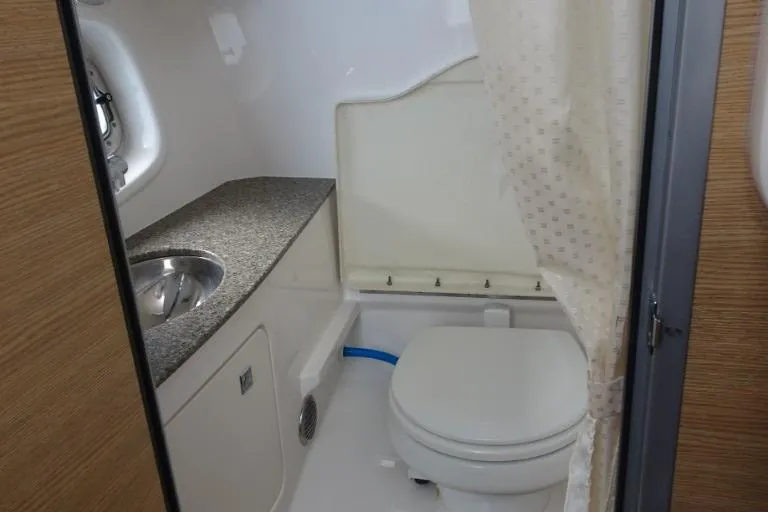Slide: The Image of 2015 Chaparral 327 SSX boat bathroom with sink, toilet, and shower curtain. - 19
