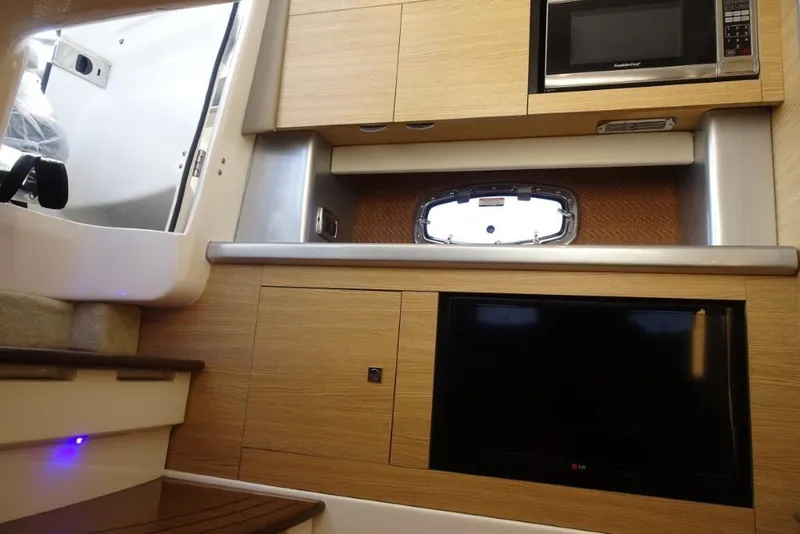 Slide: The Image of 2015 Chaparral 327 SSX interior with microwave, TV, and porthole window. - 24