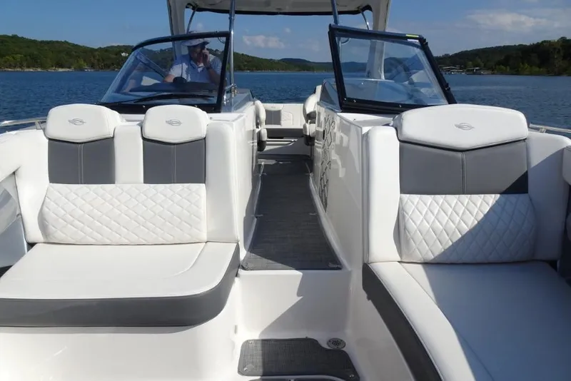 Slide: The Image of 2015 Chaparral 327 SSX boat interior with white and gray seating on a lake. - 32