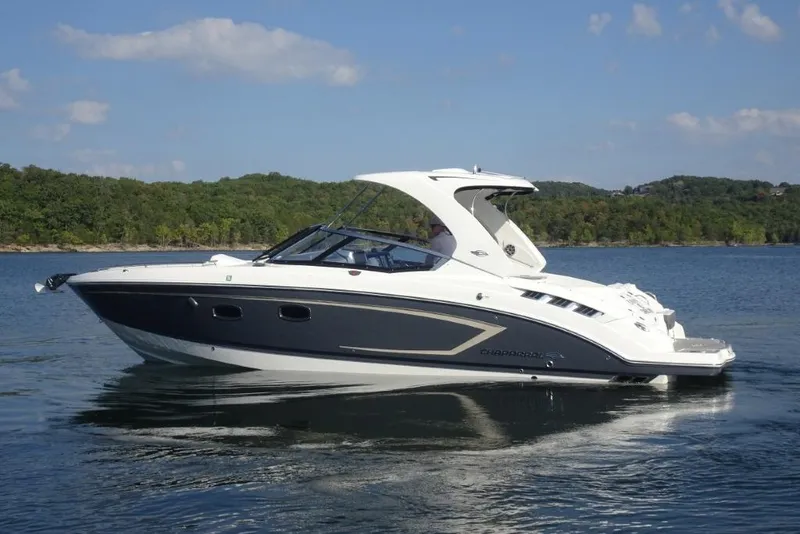 Slide: The Image of 2015 Chaparral 327 SSX boat on a serene lake with forested shoreline. - 4