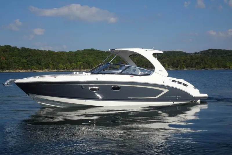 Slide: The Image of 2015 Chaparral 327 SSX boat on a serene lake with forested shoreline. - 5
