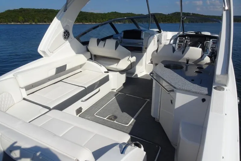 Slide: The Image of 2015 Chaparral 327 SSX boat interior with white seating and modern dashboard. - 9
