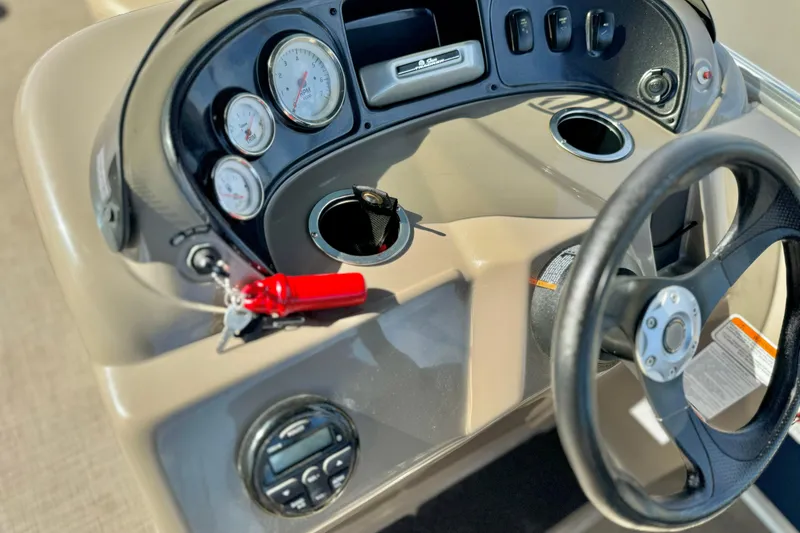Slide: The Image of 2021 Sun Tracker Party Barge 18 DLX dashboard with steering wheel and gauges. - 15