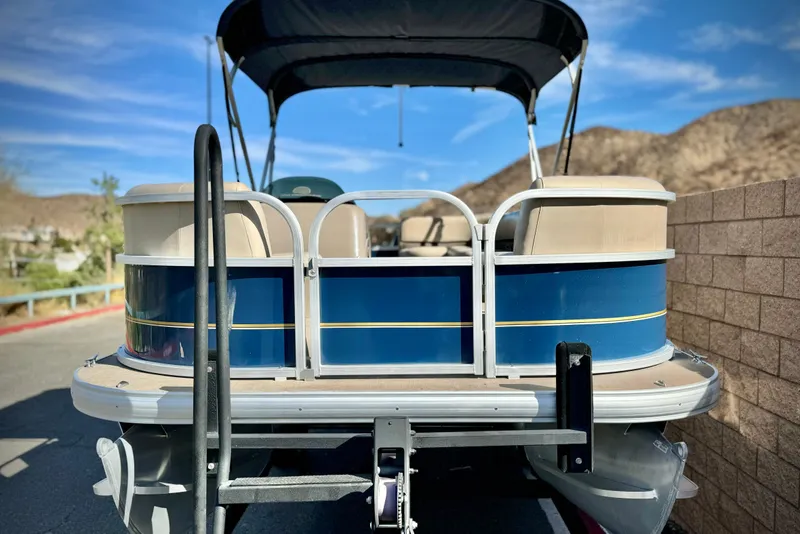 Slide: The Image of 2021 Sun Tracker Party Barge 18 DLX pontoon boat, parked outdoors, blue and beige design. - 3