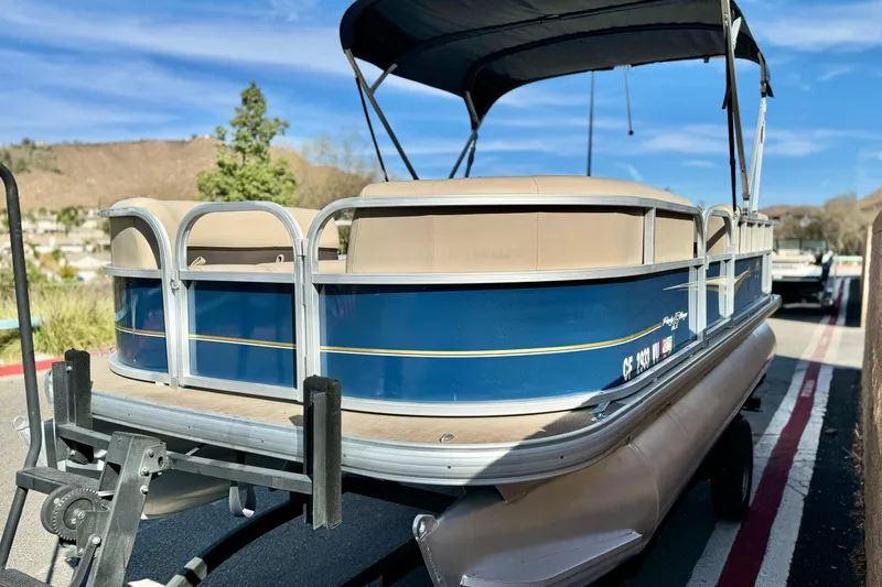 Slide: The Image of 2021 Sun Tracker Party Barge 18 DLX pontoon boat on trailer, parked outdoors. - 4