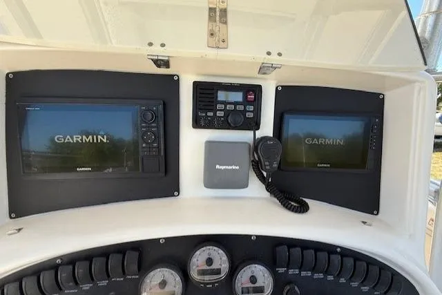 Slide: The Image of 2004 Boston Whaler 320 Outrage dashboard with Garmin displays and Raymarine equipment. - 10
