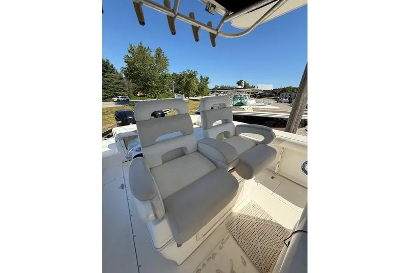 Slide: The Image of 2004 Boston Whaler 320 Outrage boat interior with comfortable seating and clear blue sky. - 12