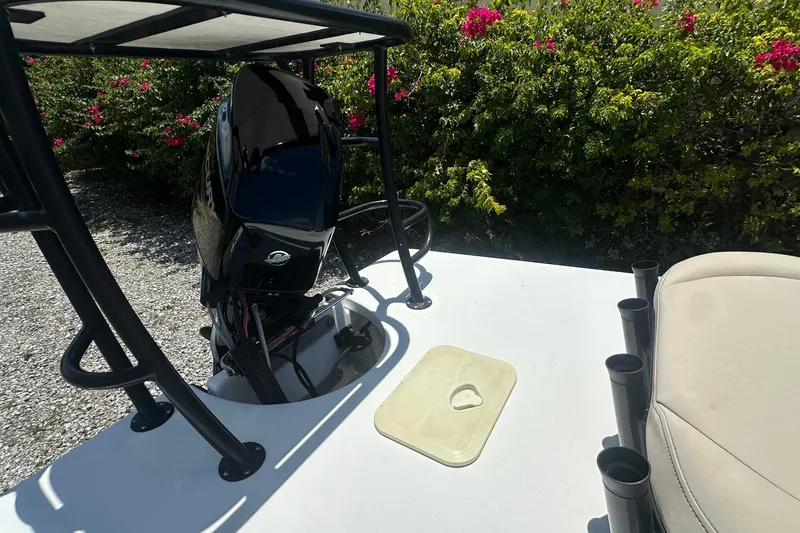 Slide: The Image of 2024 Delta 18 boat deck with motor, rod holders, and seating, surrounded by lush greenery. - 4