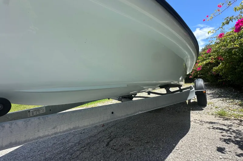 Slide: The Image of 2024 Delta Boatworks Delta 18 on trailer, surrounded by vibrant flowers. - 6