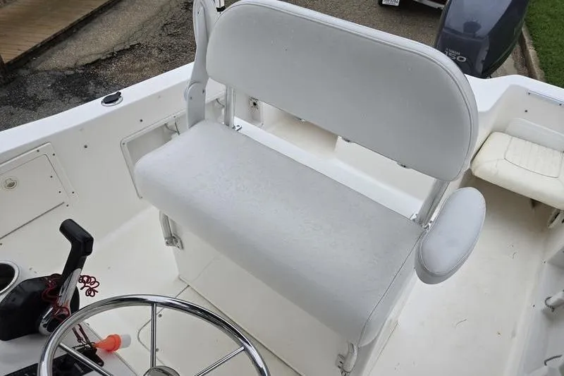 Slide: The Image of 2007 Sea Hunt Triton 220 boat interior with white seating and steering wheel. - 10