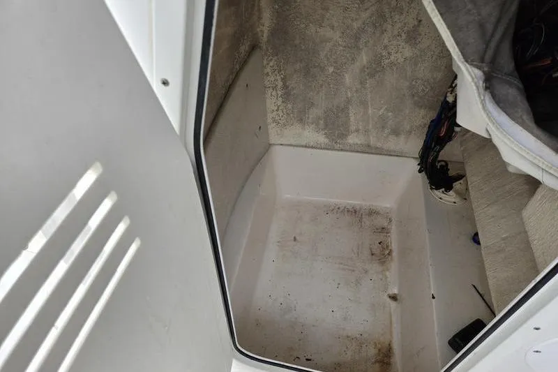 Slide: The Image of 2007 Sea Hunt Triton 220 boat interior, showing storage compartment with visible wear. - 14