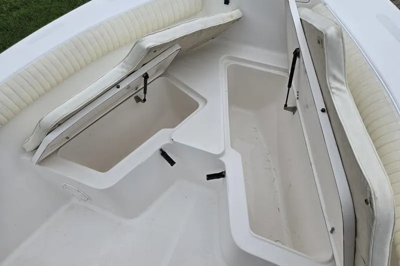 Slide: The Image of 2007 Sea Hunt Triton 220 boat storage compartments with open cushioned seats. - 6